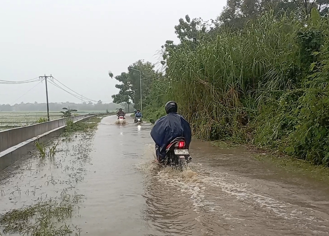 Sedikitnya terlihat tiga sepeda motor terpaksa didorong oleh pemiliknya setelah nekat menerjang genangan air
